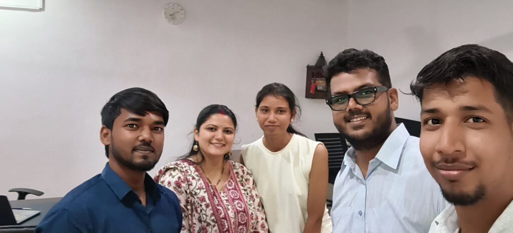 Team members of Nueva Digital Solution smiling together in the office, capturing a farewell moment filled with teamwork and positivity.