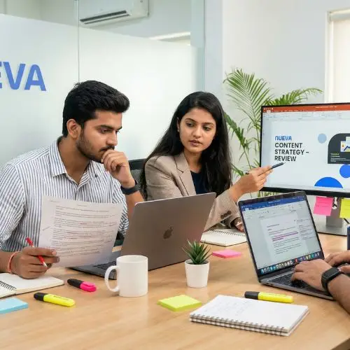Three young professionals from the Nueva team collaborating in a digital marketing office during content review and content creation, refining drafts on laptops and printed documents.
